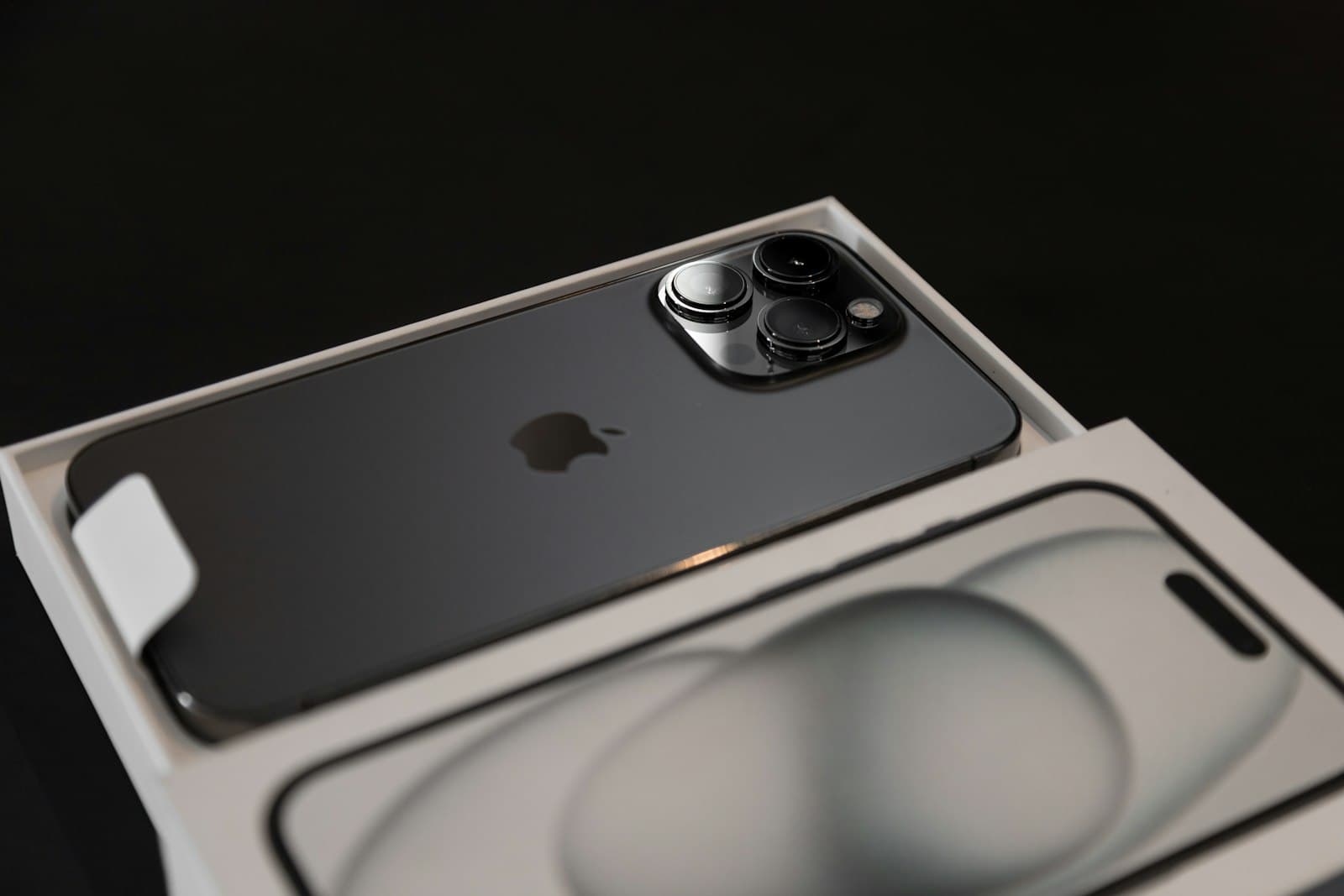 iPhone en su caja sobre fondo negro